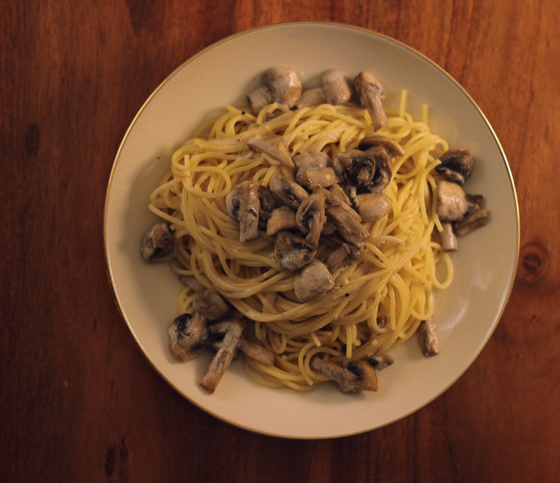 Spaghetti in Champignonssoße auf dem Teller angerichtet