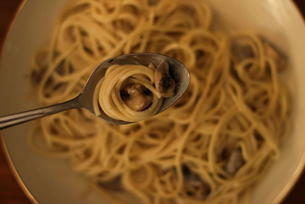 Spaghetti Champignonssoße auf einem Löffel großaufnahme
