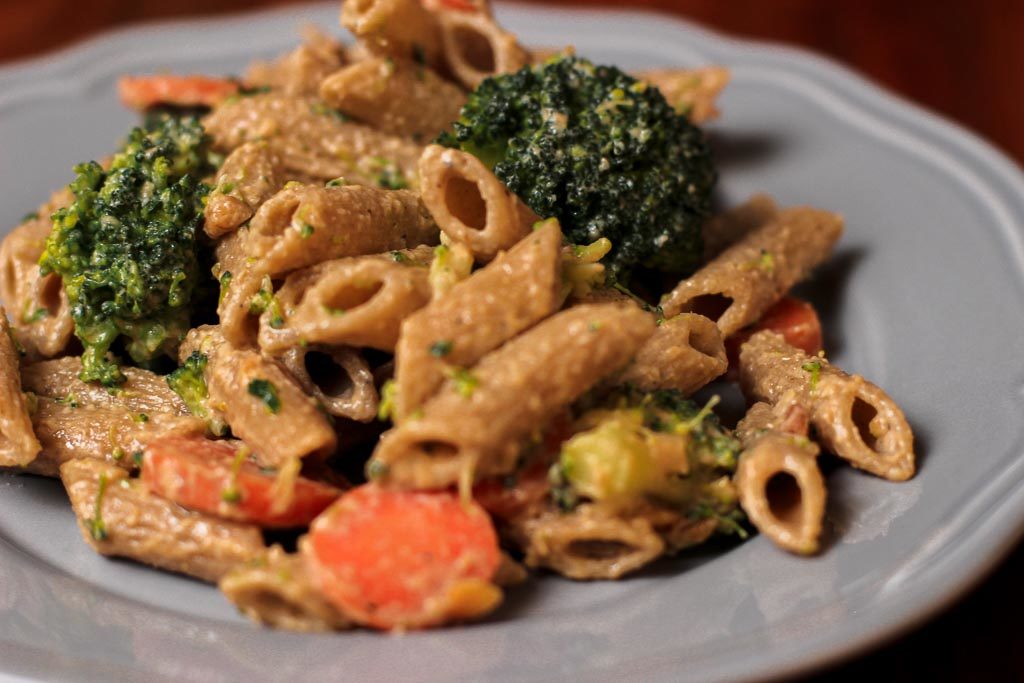 Vollkorn Penne mit Brokkoli Saté Soße angerichtet auf einem Teller