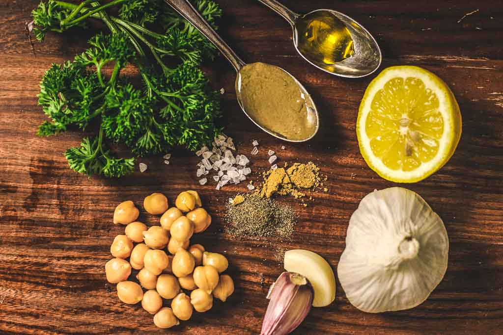 Zutatenliste für grünen Hummus - Petersilie, Kichererbsen, Zitrone. Öl und Tahin